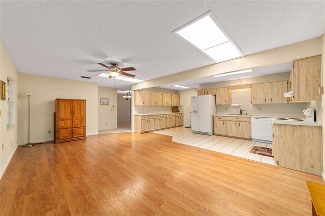 8704 SW 94th Ln Unit G, Ocala, FL 34481 - kitchen featuring white appliances, light brown cabinetry, light countertops, light wood-style flooring, and a textured ceiling