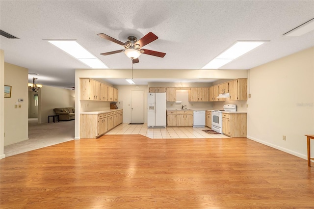 8704 SW 94th Ln Unit G, Ocala, FL 34481 - kitchen featuring white appliances, light brown cabinets, ceiling fan, light countertops, and a skylight