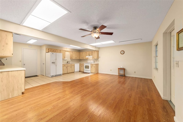8704 SW 94th Ln Unit G, Ocala, FL 34481 - unfurnished living room featuring ceiling fan, a skylight, and light wood-style flooring