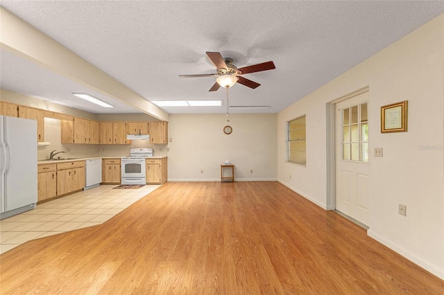 8704 SW 94th Ln Unit G, Ocala, FL 34481 - kitchen with white appliances, under cabinet range hood, light countertops, a ceiling fan, and light wood finished floors