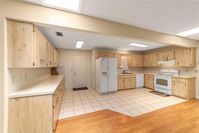 8704 SW 94th Ln Unit G, Ocala, FL 34481 - kitchen featuring white appliances, under cabinet range hood, light brown cabinetry, and light countertops