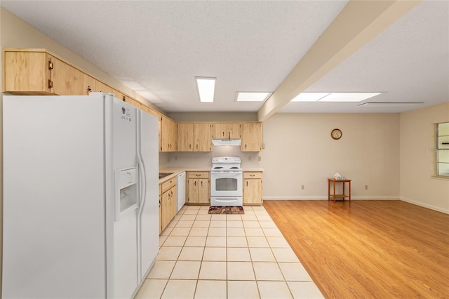 8704 SW 94th Ln Unit G, Ocala, FL 34481 - kitchen with white appliances, light brown cabinetry, light countertops, under cabinet range hood, and a textured ceiling