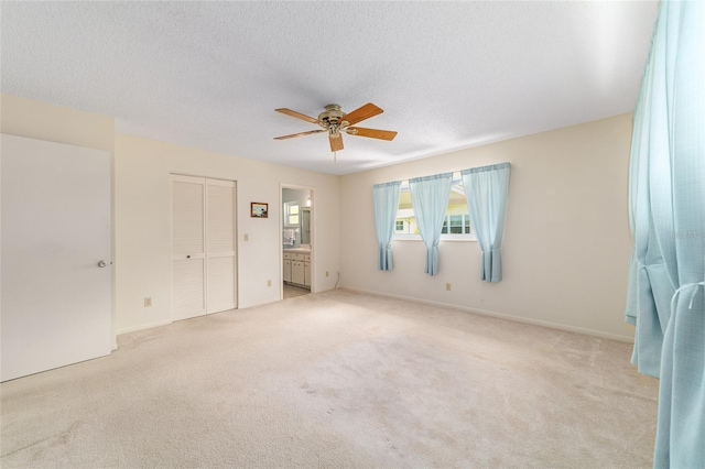 8704 SW 94th Ln Unit G, Ocala, FL 34481 - unfurnished bedroom with light colored carpet, ensuite bath, a closet, a ceiling fan, and a textured ceiling