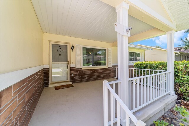 8704 SW 94th Ln Unit G, Ocala, FL 34481 - doorway to property with covered porch and brick siding