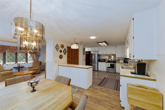 3427 SE 137th St, Summerfield, FL 34491 - dining space with light wood-style flooring and a chandelier