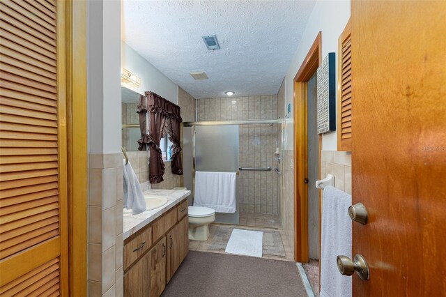3427 SE 137th St, Summerfield, FL 34491 - full bath featuring vanity, a stall shower, a textured ceiling, tile walls, and a closet