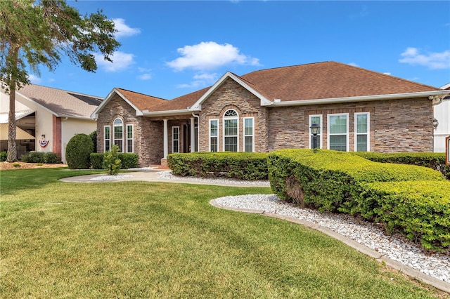 9641 SE 70th Ter, Ocala, FL 34472 - single story home with stone siding, a front yard, and a shingled roof
