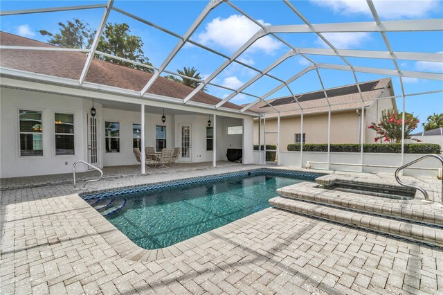 9641 SE 70th Ter, Ocala, FL 34472 - view of swimming pool featuring a patio area, glass enclosure, and a pool with connected hot tub