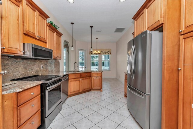 9641 SE 70th Ter, Ocala, FL 34472 - kitchen with stainless steel appliances, a peninsula, a chandelier, decorative backsplash, and light stone countertops