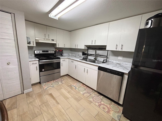 8134 Fairways Cir Unit R203, Ocala, FL 34472 - kitchen featuring stainless steel appliances, under cabinet range hood, light countertops, a textured ceiling, and white cabinets