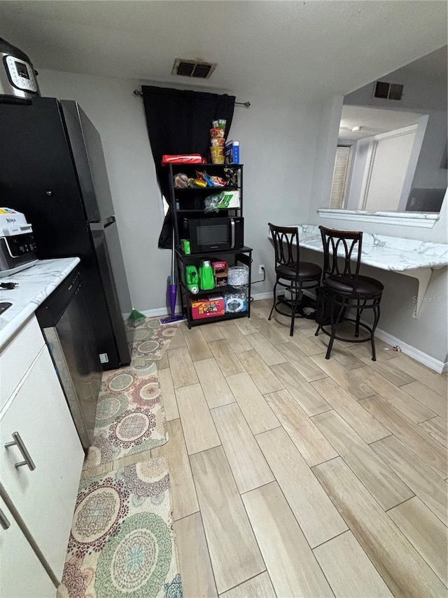 8134 Fairways Cir Unit R203, Ocala, FL 34472 - kitchen with wood tiled floors, white cabinetry, and light countertops