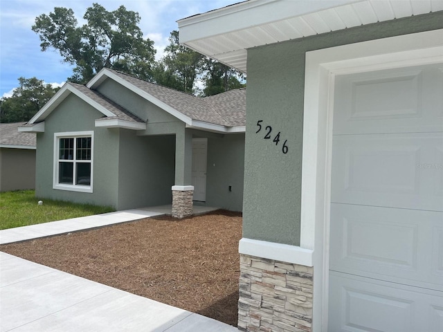 8795 Juniper Rd, Ocala, FL 34480 - entrance to property featuring stone siding, roof with shingles, and stucco siding