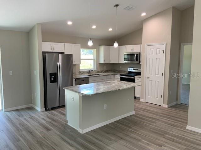 8795 Juniper Rd, Ocala, FL 34480 - kitchen with appliances with stainless steel finishes, light wood-style floors, white cabinetry, a kitchen island, and recessed lighting