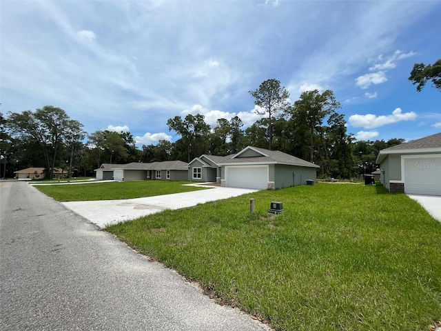 8795 Juniper Rd, Ocala, FL 34480 - ranch-style house featuring a front yard, driveway, and stucco siding