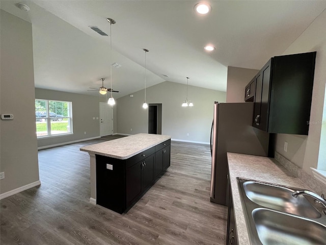 8795 Juniper Rd, Ocala, FL 34480 - kitchen with dark cabinetry, vaulted ceiling, a kitchen island, light countertops, and wood finished floors