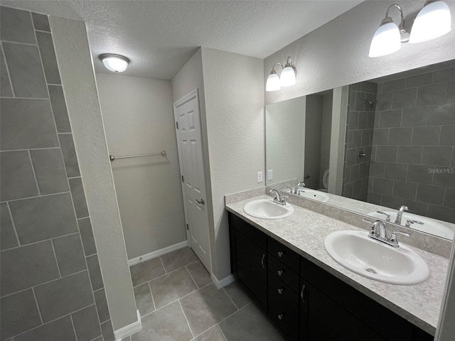 8795 Juniper Rd, Ocala, FL 34480 - bathroom featuring double vanity, a textured ceiling, tile patterned flooring, a textured wall, and a tile shower