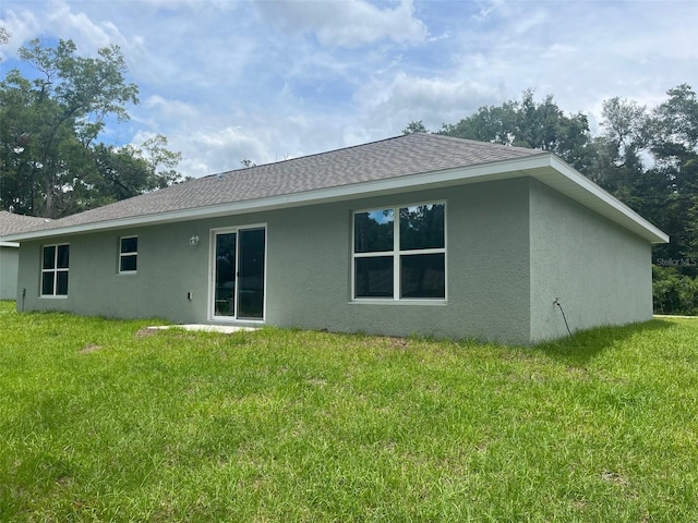 8795 Juniper Rd, Ocala, FL 34480 - rear view of house with stucco siding, a yard, and a shingled roof