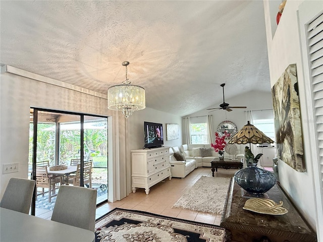 502 SE Guava Ter, Port St Lucie, FL 34983 - living area featuring a textured ceiling, a ceiling fan, a chandelier, light tile patterned floors, and vaulted ceiling