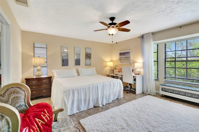 502 SE Guava Ter, Port St Lucie, FL 34983 - tiled bedroom featuring a textured ceiling and ceiling fan