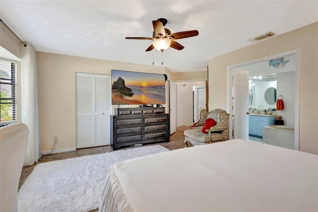 502 SE Guava Ter, Port St Lucie, FL 34983 - tiled bedroom featuring a ceiling fan and connected bathroom