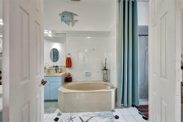 502 SE Guava Ter, Port St Lucie, FL 34983 - bathroom featuring tile patterned flooring, a garden tub, vanity, curtained shower, and tile walls