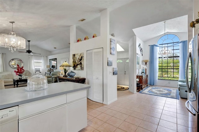 502 SE Guava Ter, Port St Lucie, FL 34983 - kitchen with vaulted ceiling, open floor plan, a chandelier, freestanding refrigerator, and light tile patterned floors