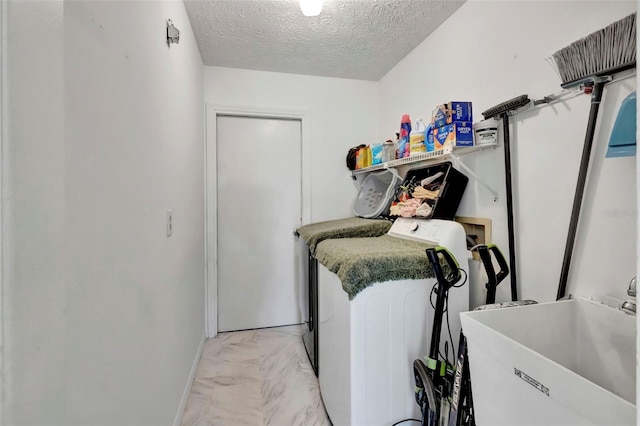 502 SE Guava Ter, Port St Lucie, FL 34983 - laundry room with washer and dryer, light marble finish flooring, and a textured ceiling