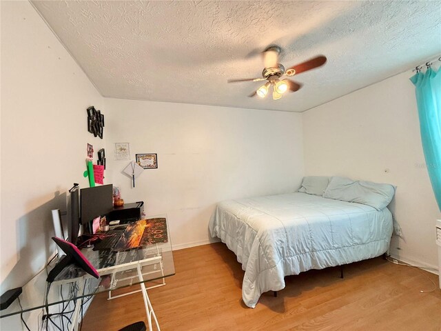 502 SE Guava Ter, Port St Lucie, FL 34983 - bedroom with a textured ceiling, wood finished floors, and ceiling fan