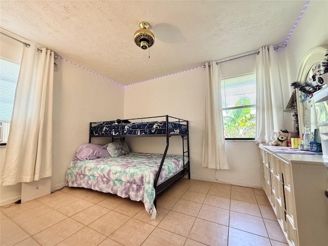 502 SE Guava Ter, Port St Lucie, FL 34983 - bedroom featuring a textured ceiling, light tile patterned flooring, and a ceiling fan