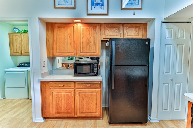 585 W Barrymore Dr, Beverly Hills, FL 34465 - kitchen with black appliances, washer / clothes dryer, light wood-style floors, and light countertops