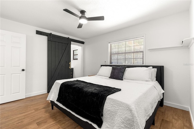 802 NE 39th Ct, Ocala, FL 34470 - bedroom with a barn door, wood finished floors, and ceiling fan