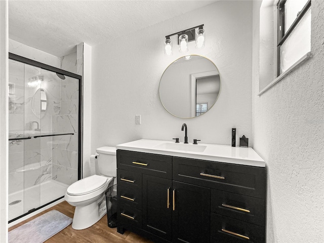 802 NE 39th Ct, Ocala, FL 34470 - full bathroom featuring vanity, a shower stall, wood finished floors, a textured ceiling, and a textured wall