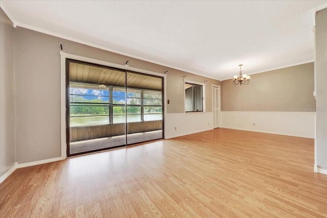 683 Midway Dr Unit B, Ocala, FL 34472 - empty room with wood finished floors, a chandelier, ornamental molding, and a wainscoted wall