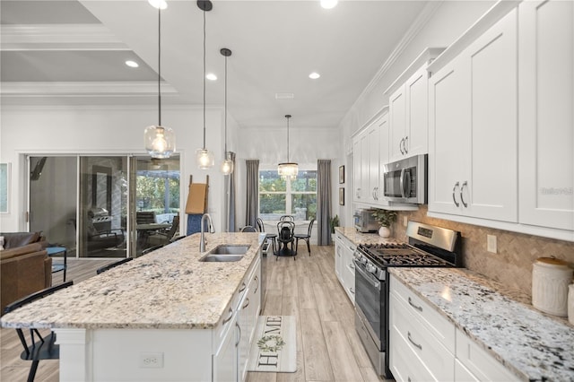 3993 SE 10th Ave, Ocala, FL 34480 - kitchen with stainless steel appliances, a kitchen island with sink, white cabinets, backsplash, and crown molding