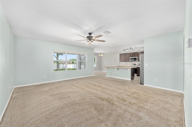 7054 SW 64th Ter, Ocala, FL 34476 - unfurnished living room with track lighting, ceiling fan, and light carpet