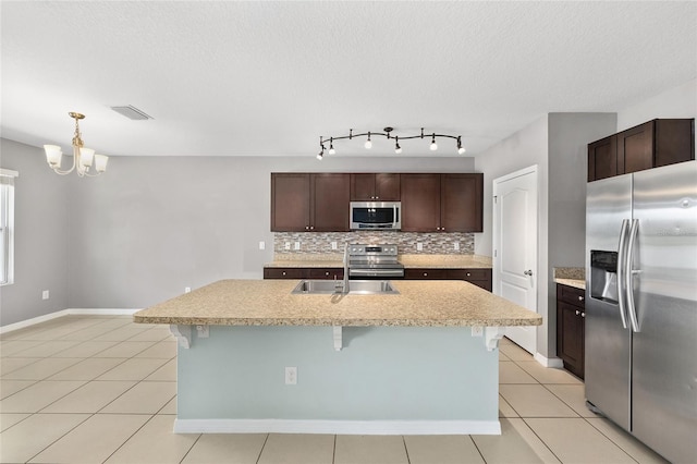 7054 SW 64th Ter, Ocala, FL 34476 - kitchen with appliances with stainless steel finishes, light countertops, backsplash, light tile patterned flooring, and a chandelier