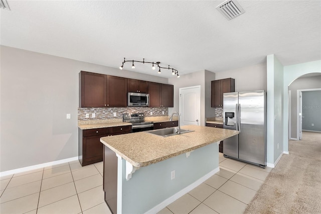 7054 SW 64th Ter, Ocala, FL 34476 - kitchen featuring stainless steel appliances, arched walkways, backsplash, dark brown cabinets, and light countertops
