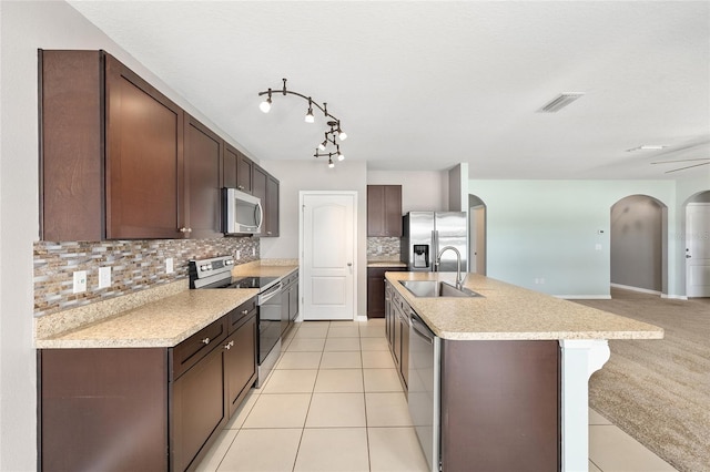 7054 SW 64th Ter, Ocala, FL 34476 - kitchen featuring appliances with stainless steel finishes, arched walkways, tasteful backsplash, and dark brown cabinets