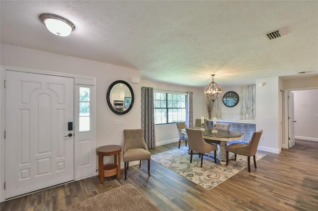2855 SE 38th St, Ocala, FL 34480 - entrance foyer featuring a textured ceiling, wood finished floors, and a chandelier