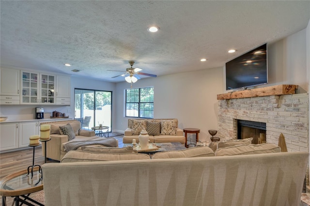 2855 SE 38th St, Ocala, FL 34480 - living room with a brick fireplace, a textured ceiling, a ceiling fan, recessed lighting, and wood finished floors