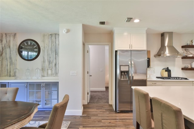 2855 SE 38th St, Ocala, FL 34480 - kitchen with appliances with stainless steel finishes, wall chimney exhaust hood, dark wood-style floors, white cabinetry, and light countertops