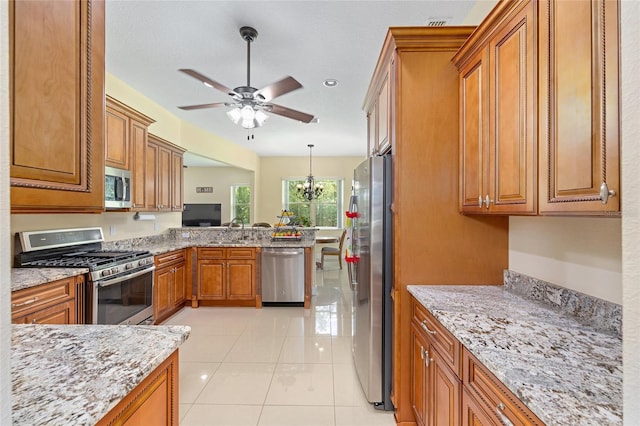 5024 SW 114th Street Rd, Ocala, FL 34476 - kitchen featuring stainless steel appliances, brown cabinetry, a peninsula, and a ceiling fan