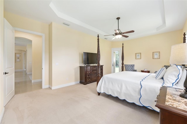 5024 SW 114th Street Rd, Ocala, FL 34476 - bedroom featuring a raised ceiling, arched walkways, light carpet, and a ceiling fan