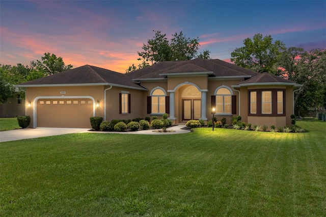 5024 SW 114th Street Rd, Ocala, FL 34476 - mediterranean / spanish home featuring an attached garage, concrete driveway, a front lawn, and stucco siding