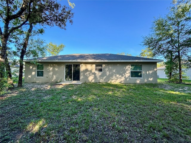10347 N Halsey Way, Dunnellon, FL 34434 - back of house featuring stucco siding and a yard