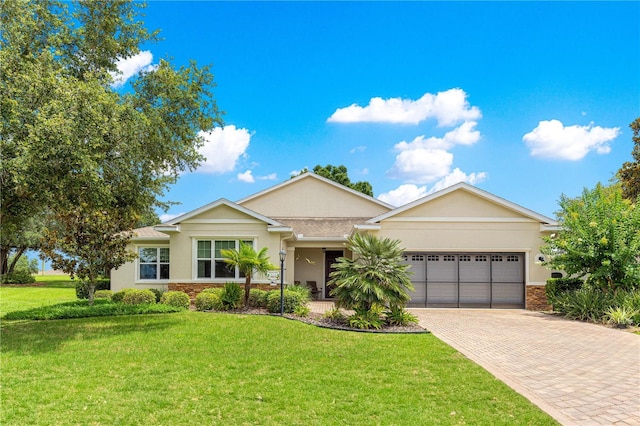 9925 SW 95th Loop, Ocala, FL 34481 - ranch-style home featuring decorative driveway, an attached garage, stucco siding, and a front yard