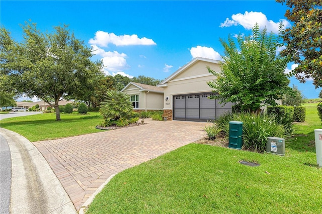 9925 SW 95th Loop, Ocala, FL 34481 - view of front of home featuring stone siding, decorative driveway, stucco siding, an attached garage, and a front yard