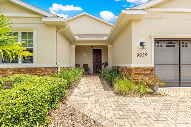 9925 SW 95th Loop, Ocala, FL 34481 - view of exterior entry with stone siding, stucco siding, and a garage