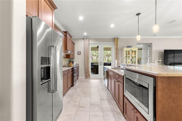 9925 SW 95th Loop, Ocala, FL 34481 - kitchen featuring appliances with stainless steel finishes, crown molding, french doors, brown cabinets, and hanging light fixtures