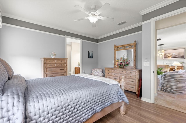 9925 SW 95th Loop, Ocala, FL 34481 - bedroom with wood finished floors, crown molding, ceiling fan, and a chandelier